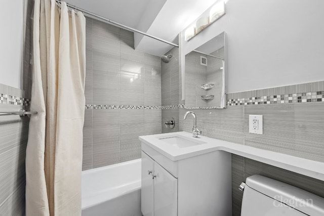 full bathroom featuring tile walls, vanity, shower / bath combination with curtain, and toilet