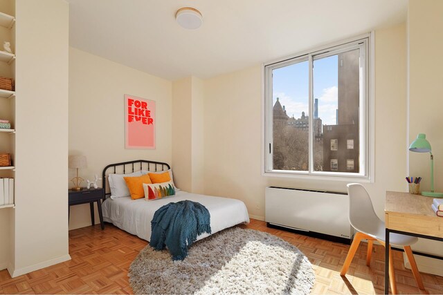 bedroom featuring light parquet floors and radiator