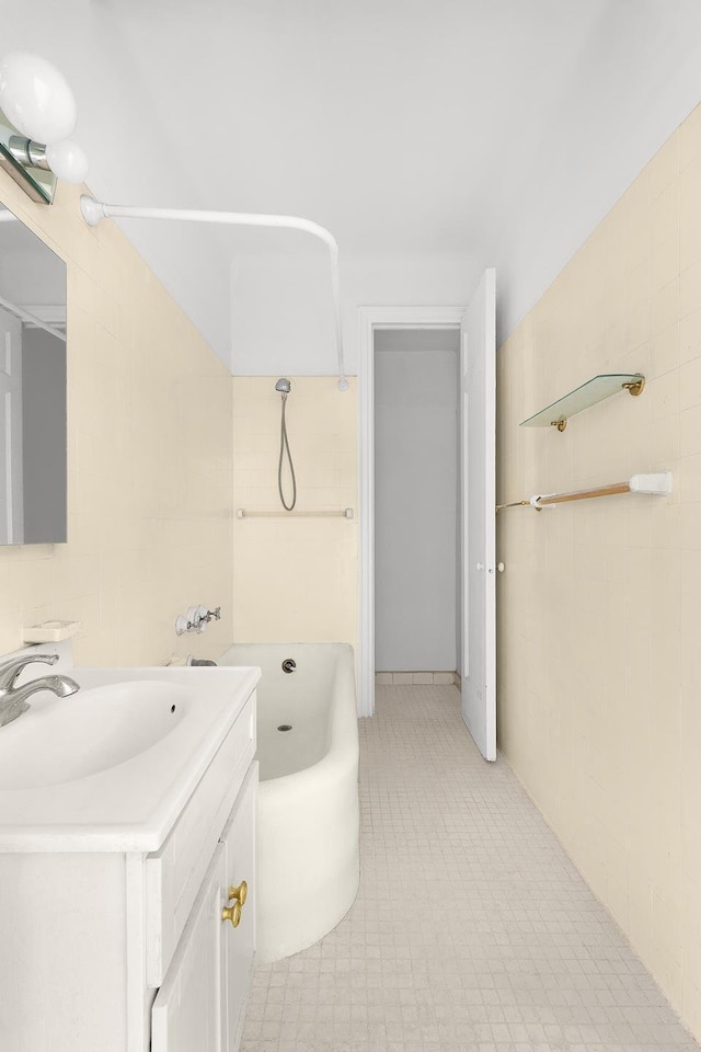 full bathroom featuring tile walls, vanity, and a bath