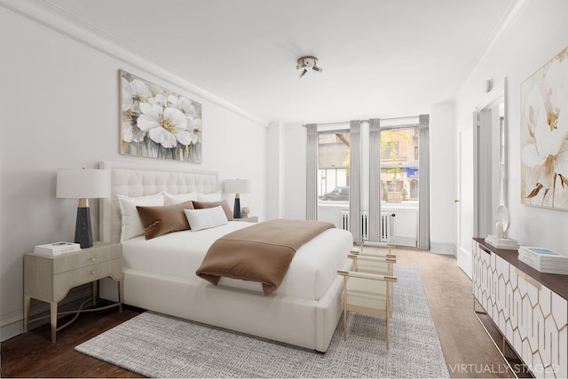 bedroom featuring radiator heating unit, wood finished floors, and crown molding