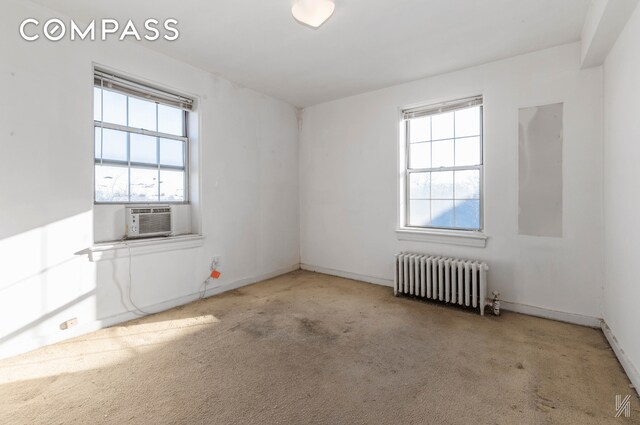 unfurnished room featuring radiator, baseboards, cooling unit, and carpet flooring