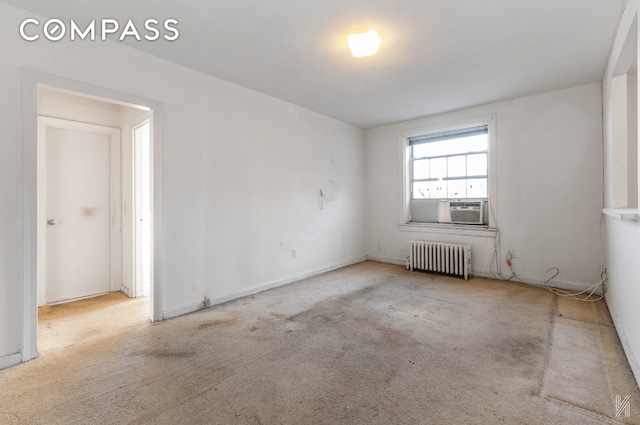 empty room featuring carpet floors, cooling unit, and radiator