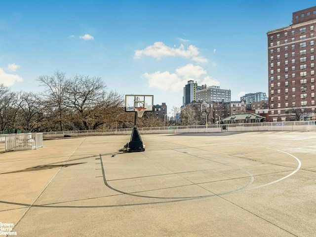 view of sport court featuring community basketball court, a view of city, and fence