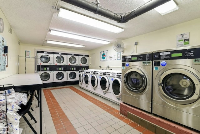 community laundry room featuring a textured ceiling, washing machine and dryer, stacked washing maching and dryer, and tile patterned flooring