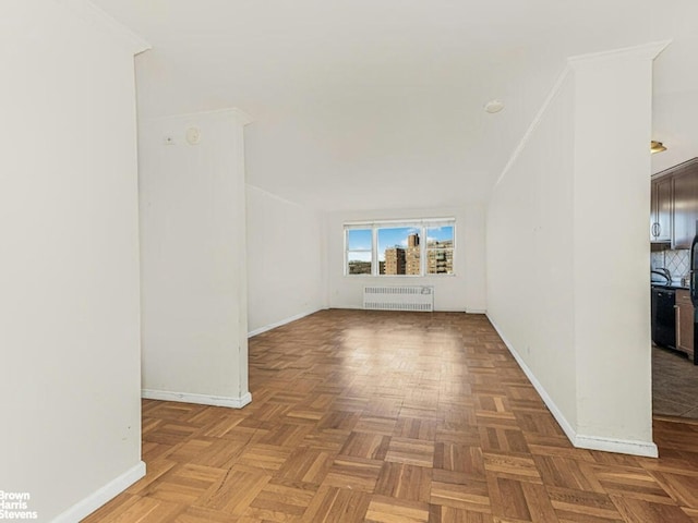 unfurnished living room featuring ornamental molding, baseboards, and radiator heating unit