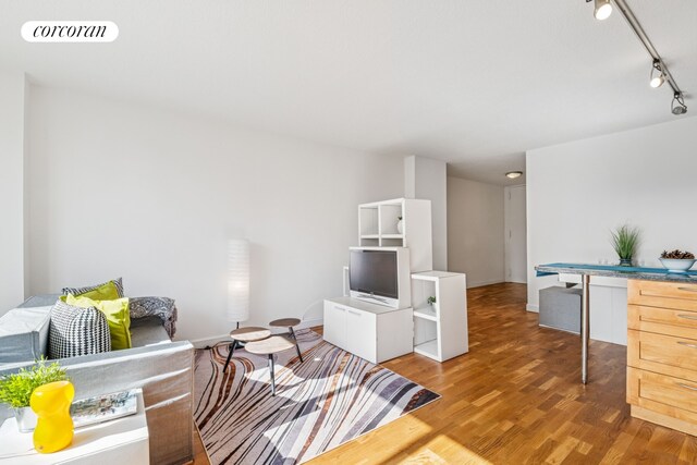 living area with light wood-type flooring, baseboards, visible vents, and track lighting