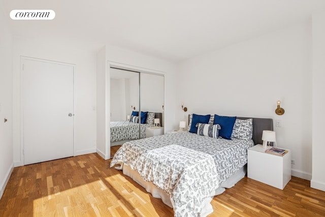 bedroom with light wood-style floors, a closet, visible vents, and baseboards