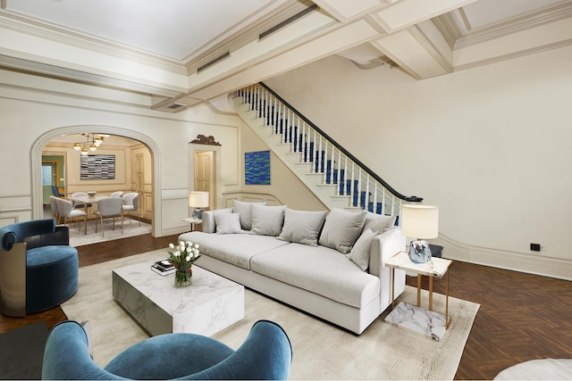 living room featuring arched walkways, a chandelier, a decorative wall, stairs, and ornamental molding