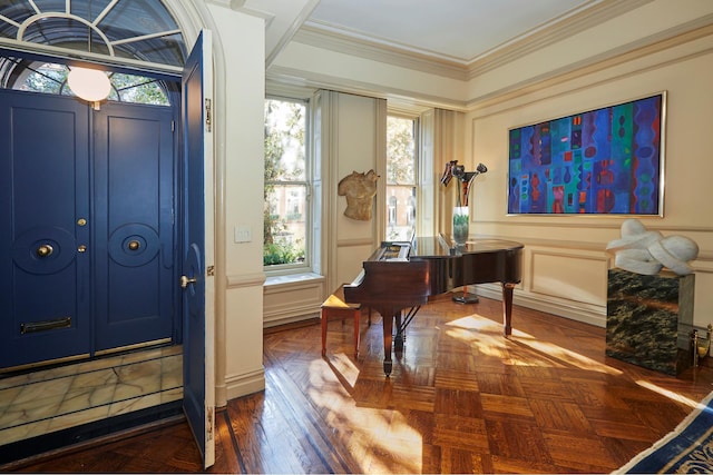 foyer with a decorative wall and crown molding