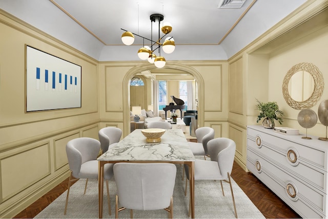 dining area featuring visible vents, arched walkways, ornamental molding, an inviting chandelier, and a decorative wall