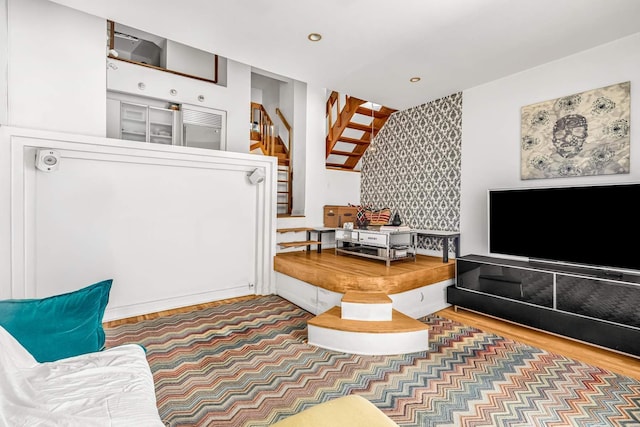 living room with recessed lighting, stairs, wood finished floors, and wallpapered walls