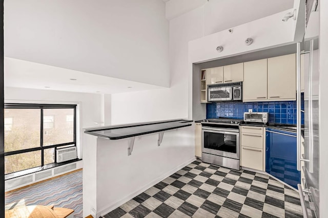 kitchen with light floors, dark countertops, stainless steel appliances, decorative backsplash, and a toaster