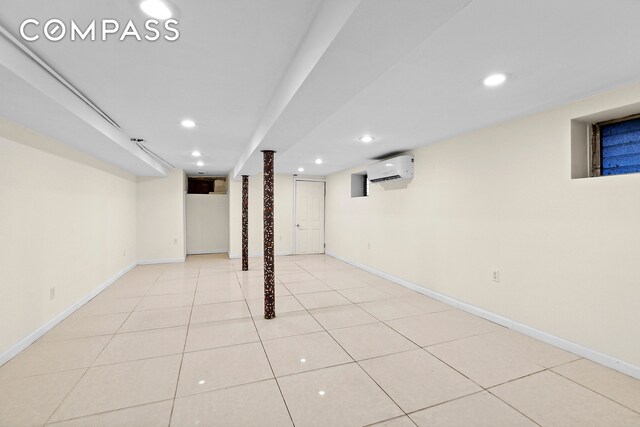 finished below grade area featuring baseboards, a wall mounted AC, and recessed lighting