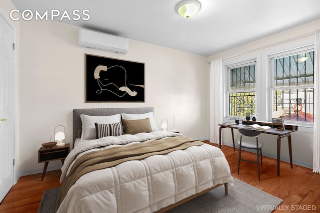 945 E 32nd St, New York City, NY 11210 - bedroom with a wall mounted AC, wood finished floors, and baseboards
