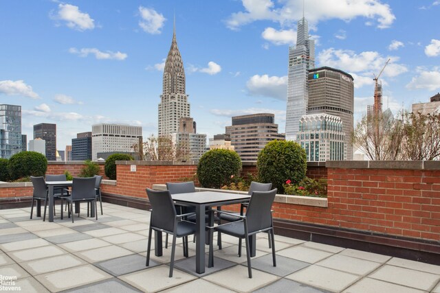 view of patio with a view of city and outdoor dining area