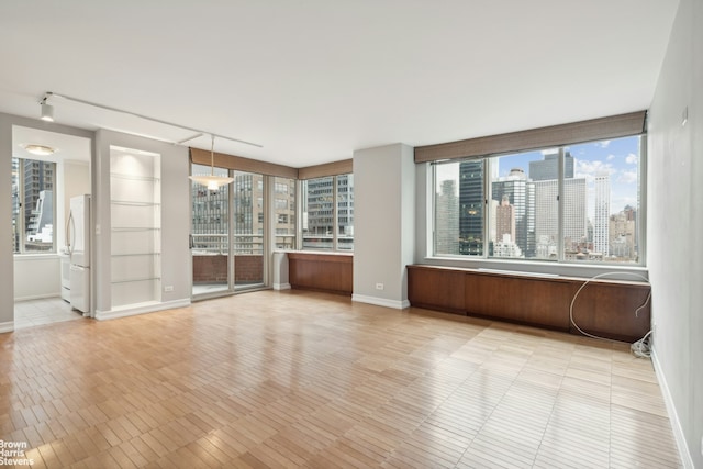 unfurnished room with baseboards and a city view