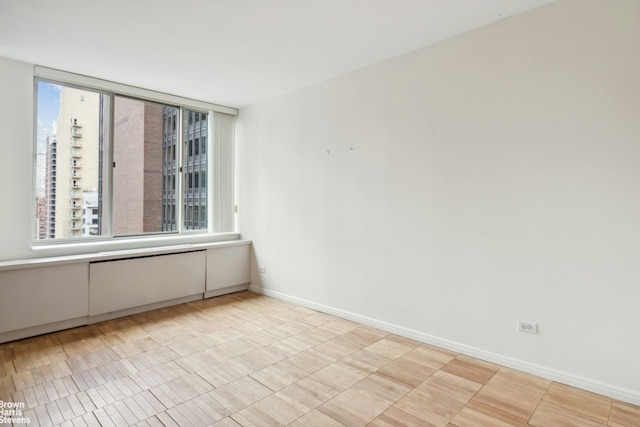 spare room featuring baseboards and a healthy amount of sunlight