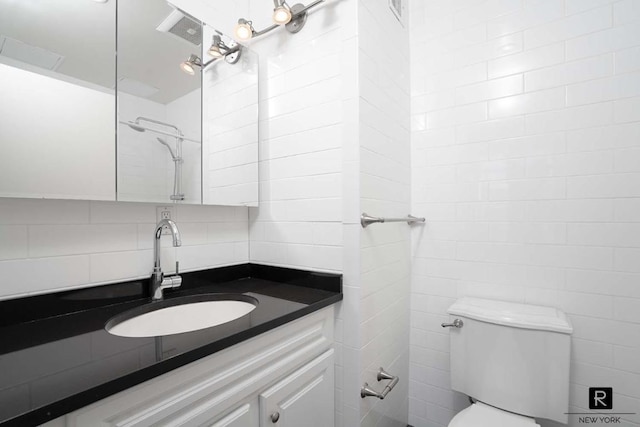 bathroom featuring tile walls, visible vents, decorative backsplash, toilet, and vanity