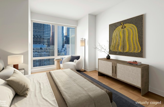 bedroom featuring baseboards, a city view, and light wood finished floors