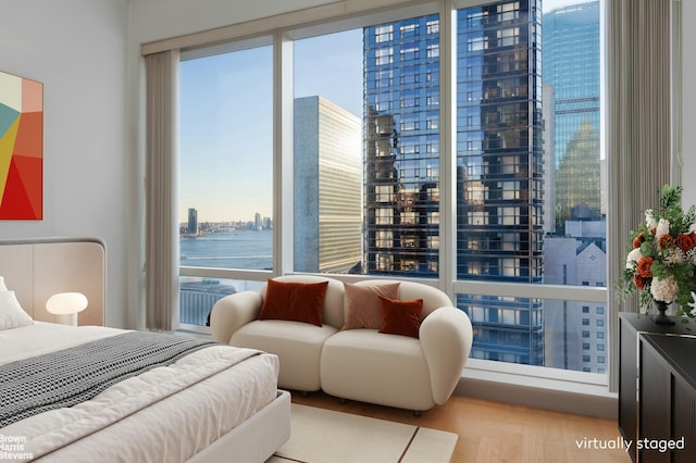 bedroom featuring light wood-style flooring and a city view