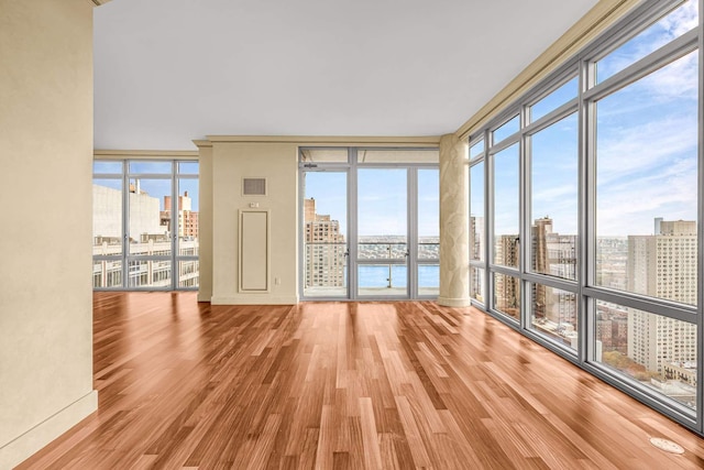 333 E 91st St Unit 31Cd, New York City, NY 10128 - empty room with a view of city, wood finished floors, and a wall of windows