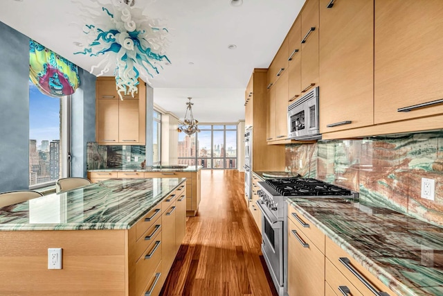 333 E 91st St Unit 31Cd, New York City, NY 10128 - kitchen with appliances with stainless steel finishes, tasteful backsplash, wood finished floors, a chandelier, and a view of skyline