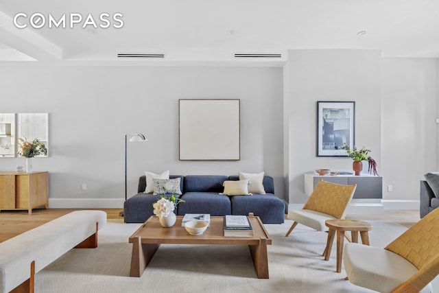 living room featuring visible vents, wood finished floors, and baseboards