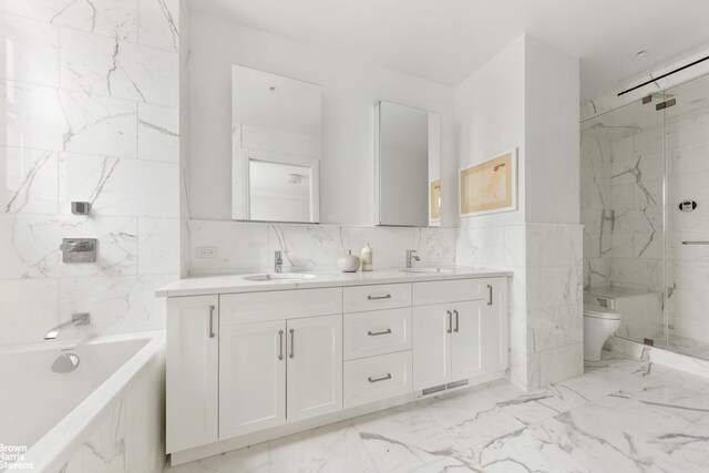 full bathroom with tile walls, vanity, independent shower and bath, and toilet