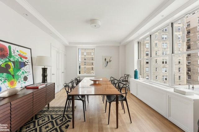 dining room featuring light wood-type flooring and ornamental molding