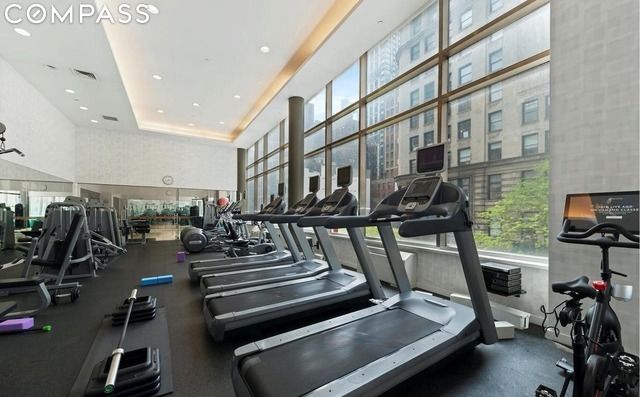 exercise room with a high ceiling and a tray ceiling