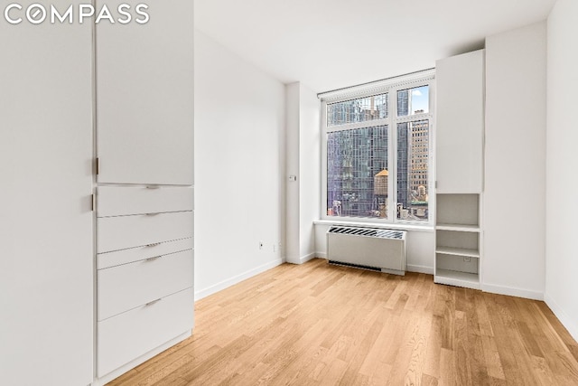 spare room featuring light hardwood / wood-style flooring and radiator heating unit