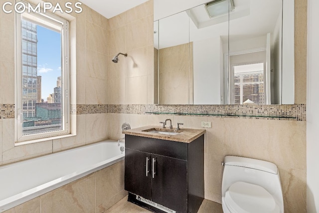 full bathroom featuring toilet, vanity, tile walls, and tiled shower / bath