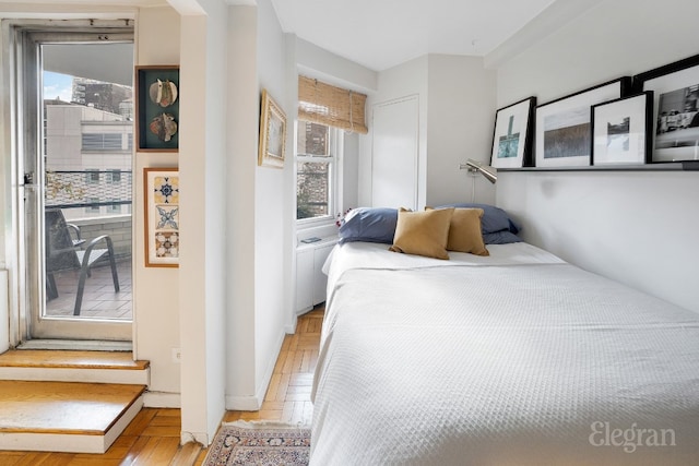 bedroom with multiple windows and light parquet flooring