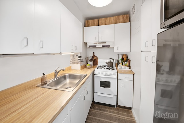 kitchen with under cabinet range hood, light countertops, white gas range, white cabinets, and a sink