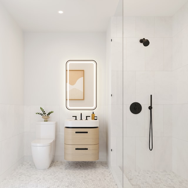 bathroom with tiled shower, toilet, tile patterned floors, vanity, and tile walls