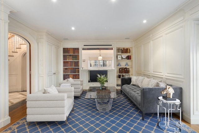 living room featuring built in shelves and ornamental molding