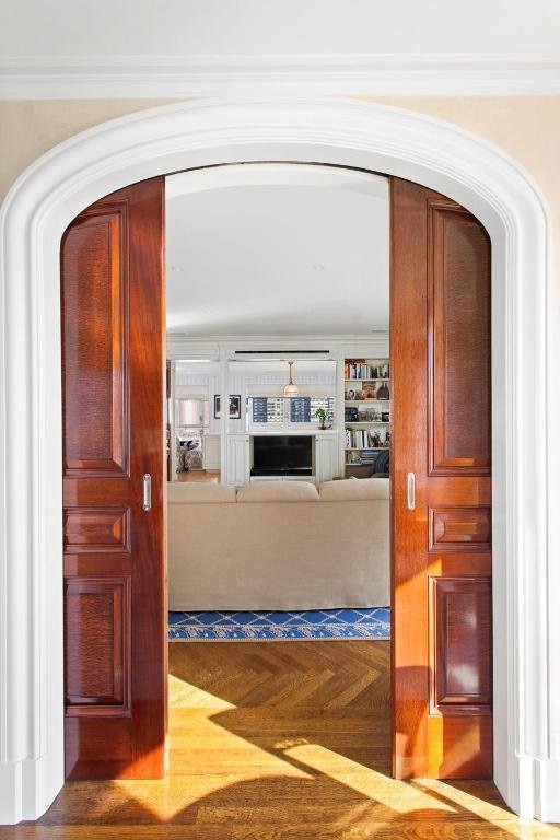 hallway with parquet flooring and ornamental molding