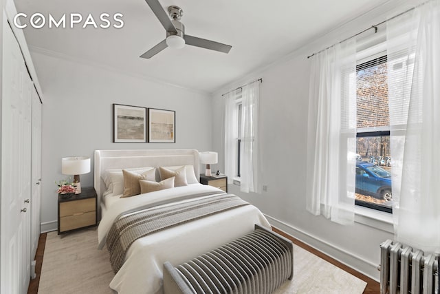 bedroom featuring radiator, multiple windows, and ornamental molding