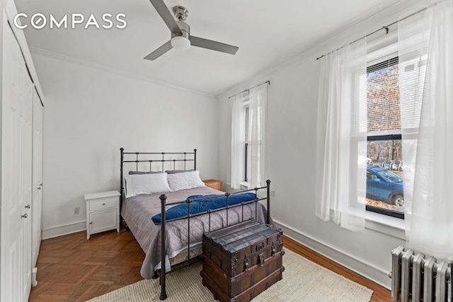 bedroom with radiator heating unit, multiple windows, ornamental molding, and ceiling fan