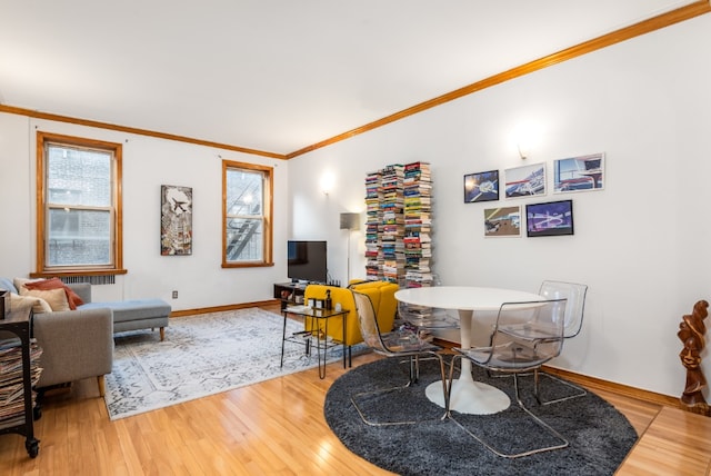 dining area featuring wood-type flooring, a wealth of natural light, and crown molding