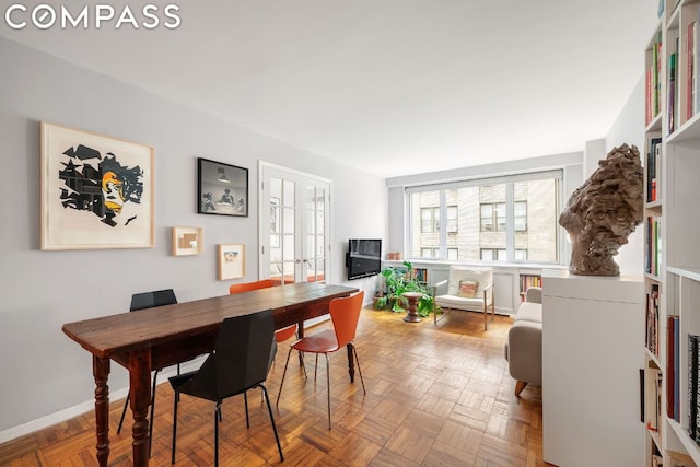 dining area featuring light parquet floors and french doors