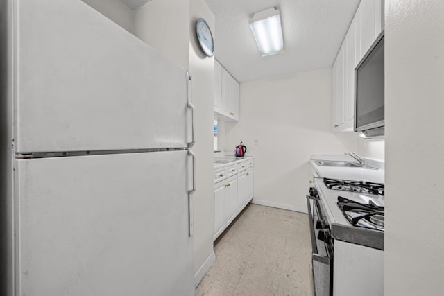 kitchen featuring sink, a textured ceiling, white cabinets, and white appliances