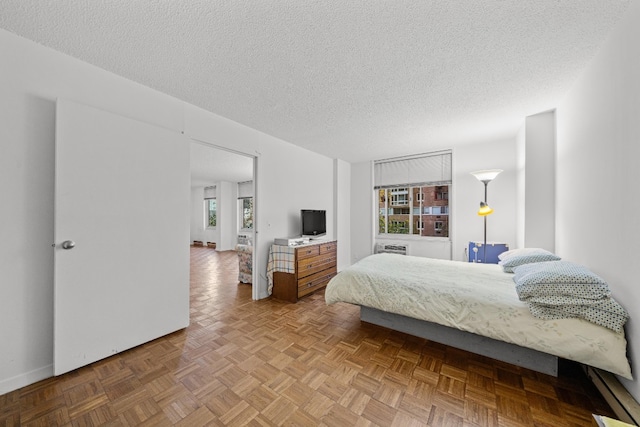 bedroom featuring parquet flooring and a textured ceiling