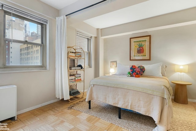 bedroom with light parquet flooring and radiator