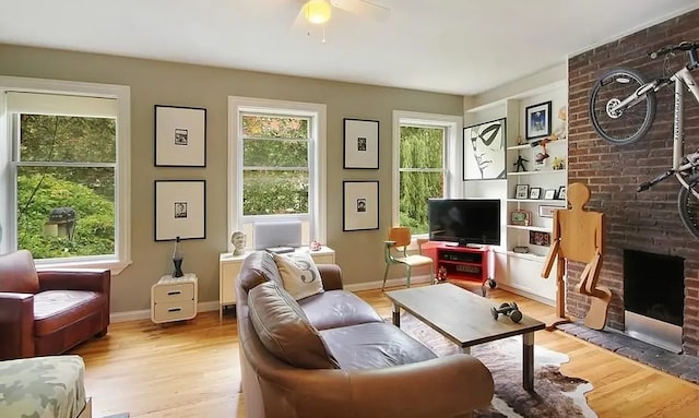 living area featuring light wood-style flooring, a fireplace, and a wealth of natural light