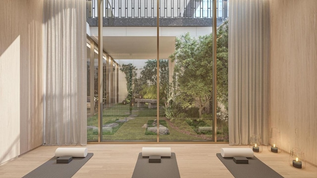 workout room featuring floor to ceiling windows and wood-type flooring