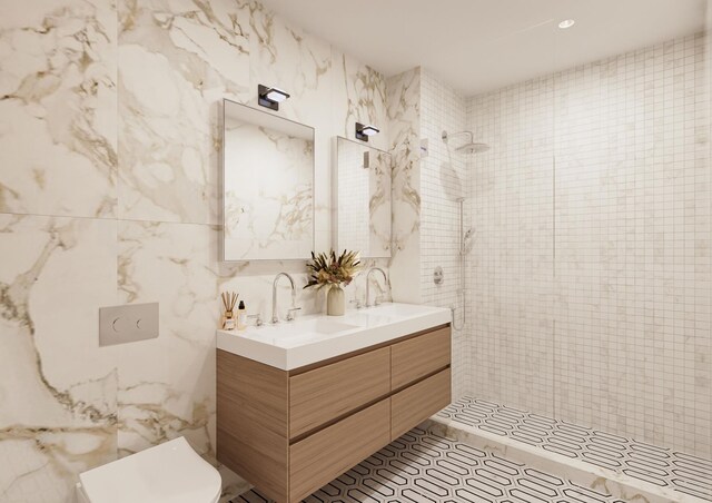 full bath with a sink, double vanity, a tile shower, and tile walls