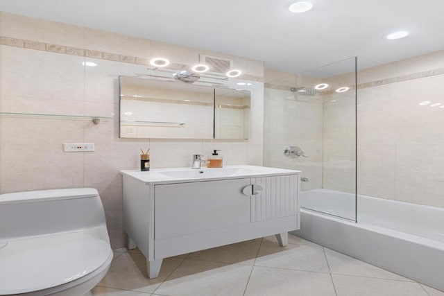 bathroom featuring visible vents, bathing tub / shower combination, toilet, vanity, and tile walls