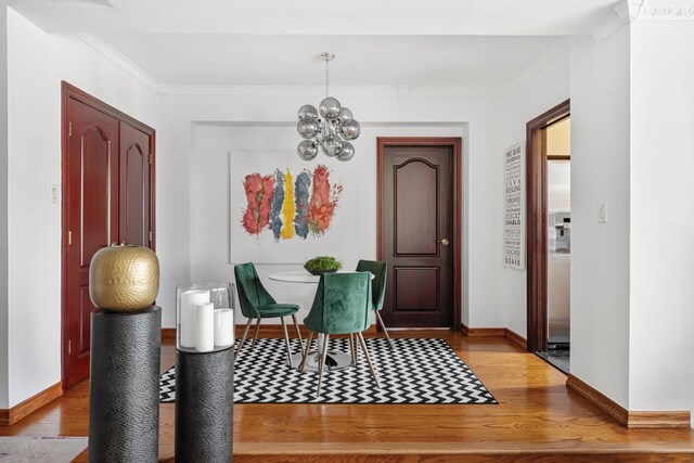98-25 64th Rd Unit 7-F, New York City, NY 11374 - entryway featuring wood finished floors, baseboards, a chandelier, and crown molding