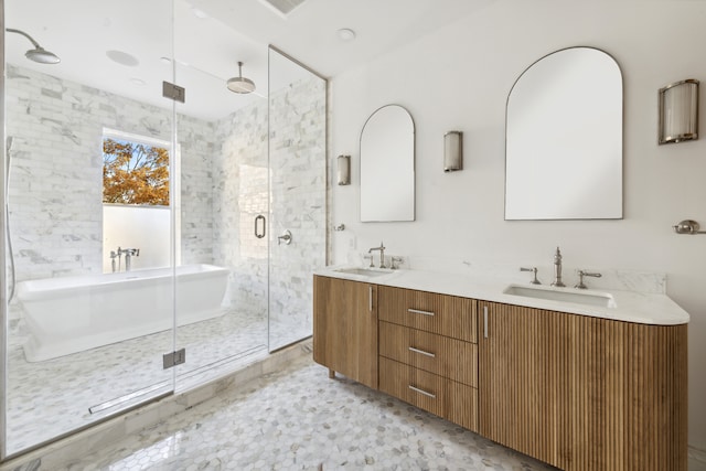 full bath featuring double vanity, a freestanding tub, a stall shower, and a sink